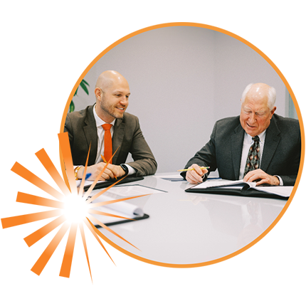 Harry and Grant Butson sitting in conference room to discuss financial futures of clients