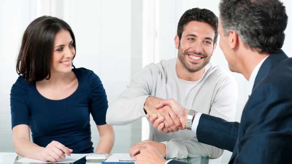 What is a Financial Plan? - Financial Advisor shaking hands with man sitting with his wife