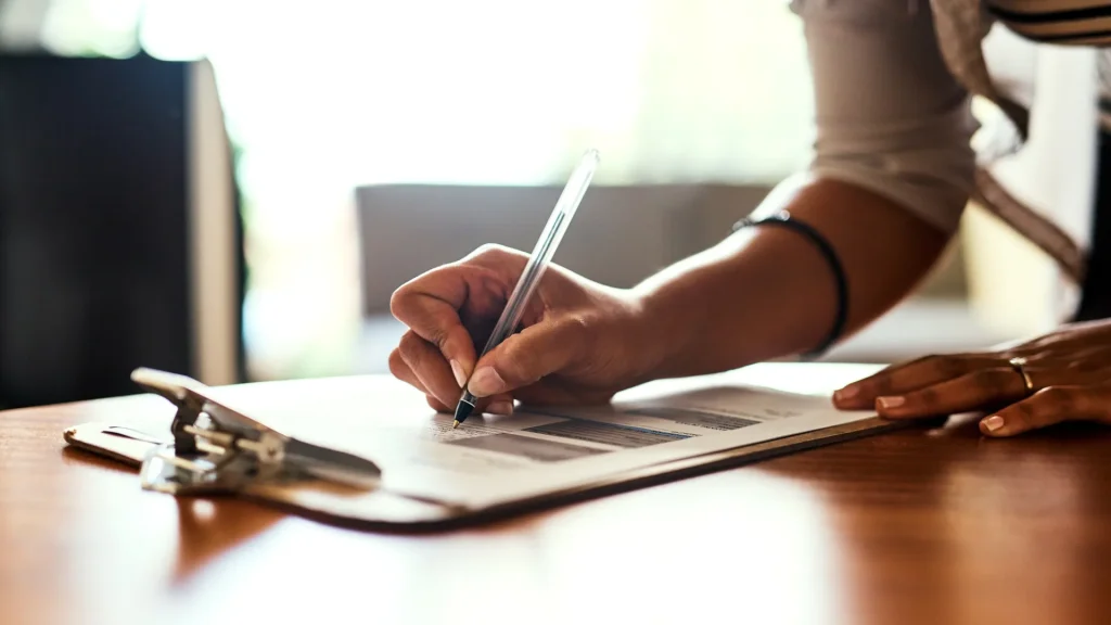 Woman filling out IRS 1099 form at a table