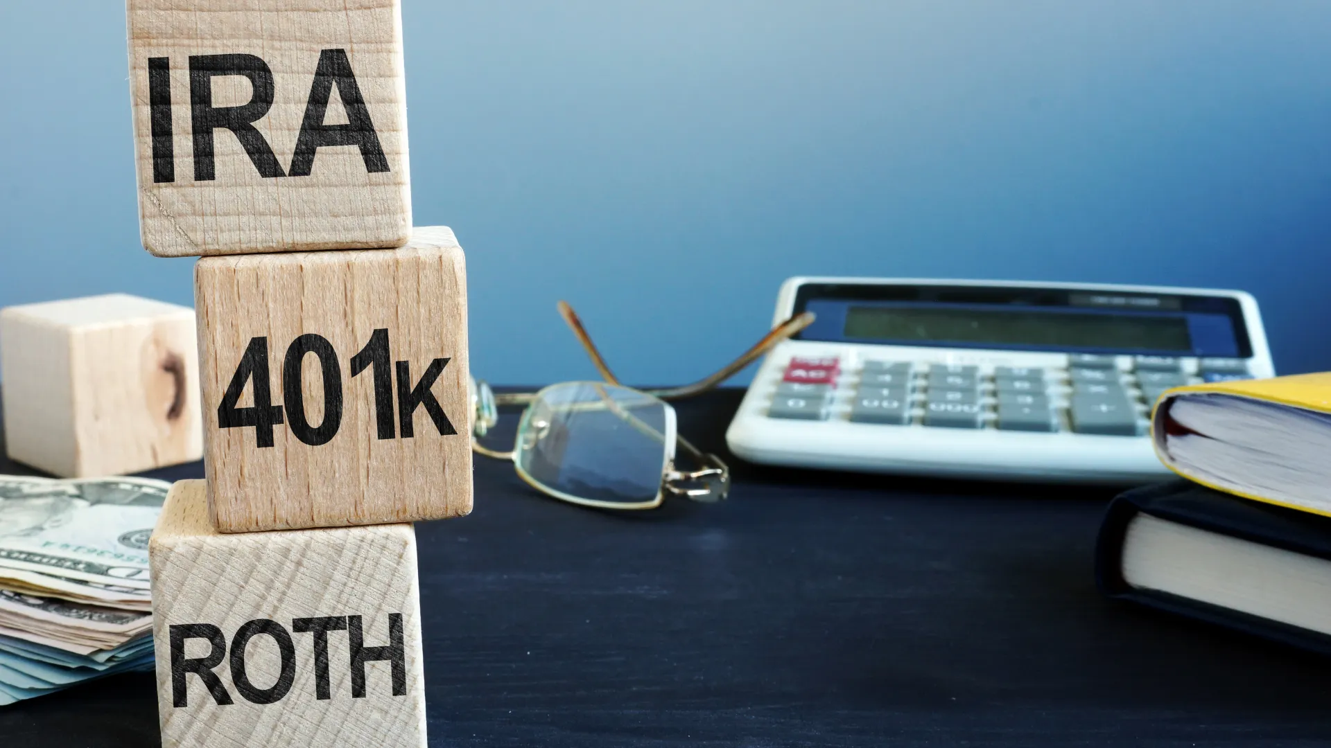 401(k) Retirement Planning - Wooden blocks stacked that say 'IRA' '401k' and 'ROTH'