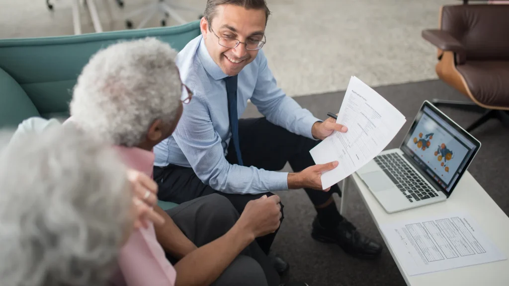 Financial advisor helping an elderly couple finalize their retirement investment