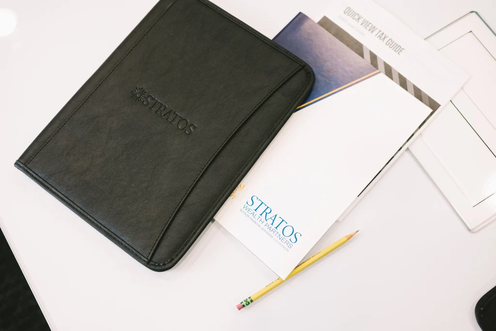 Stratos Wealth Partners notebooks and folders for financial planning and life insurance