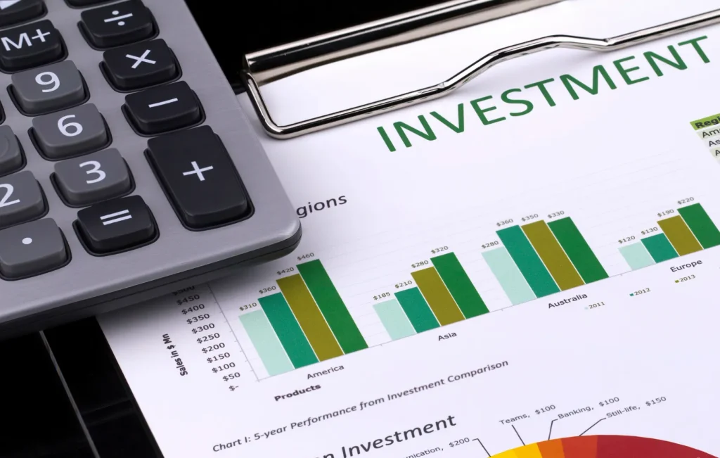 Investment document comparison with calculator sitting on top