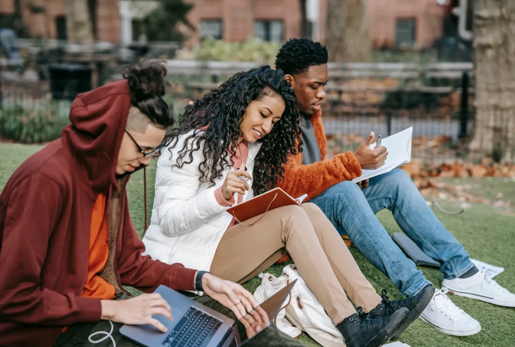 College students sitting outside to analyze their spending habits